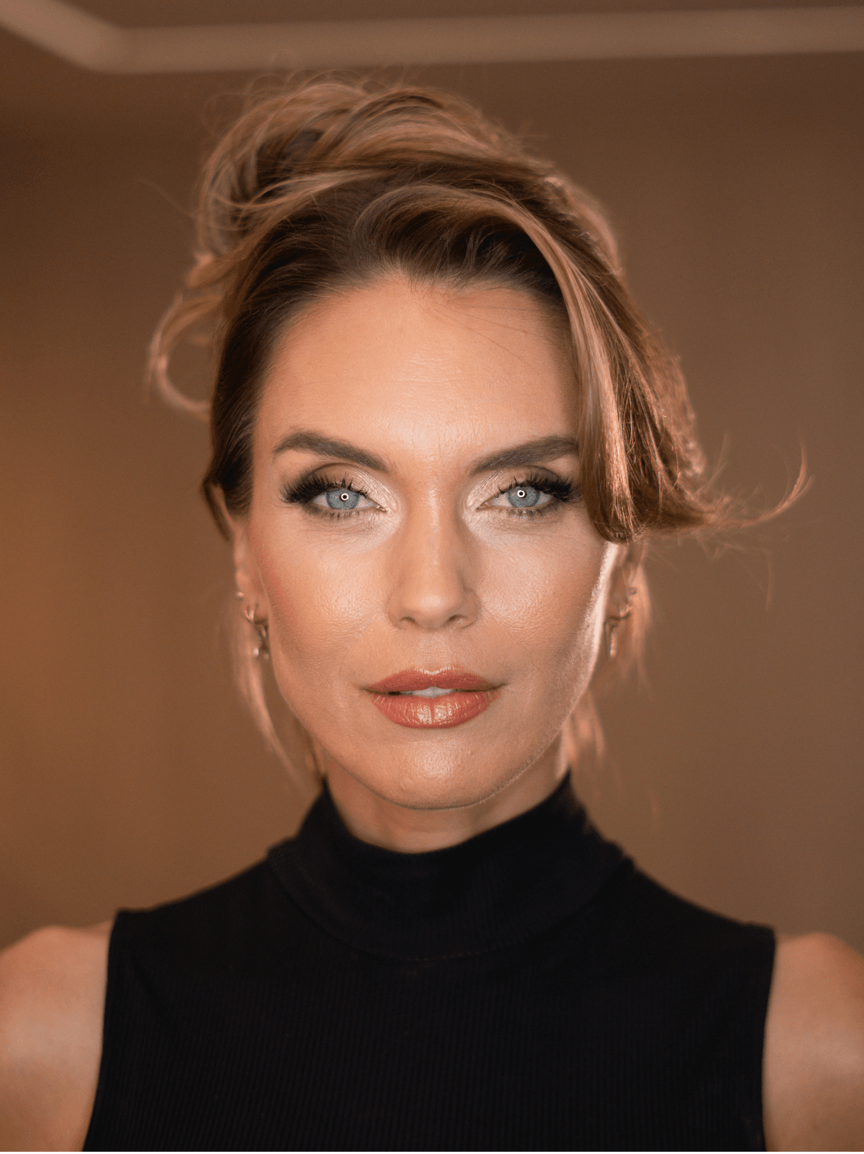 Model with a polished updo and glowing makeup by All Star Concept