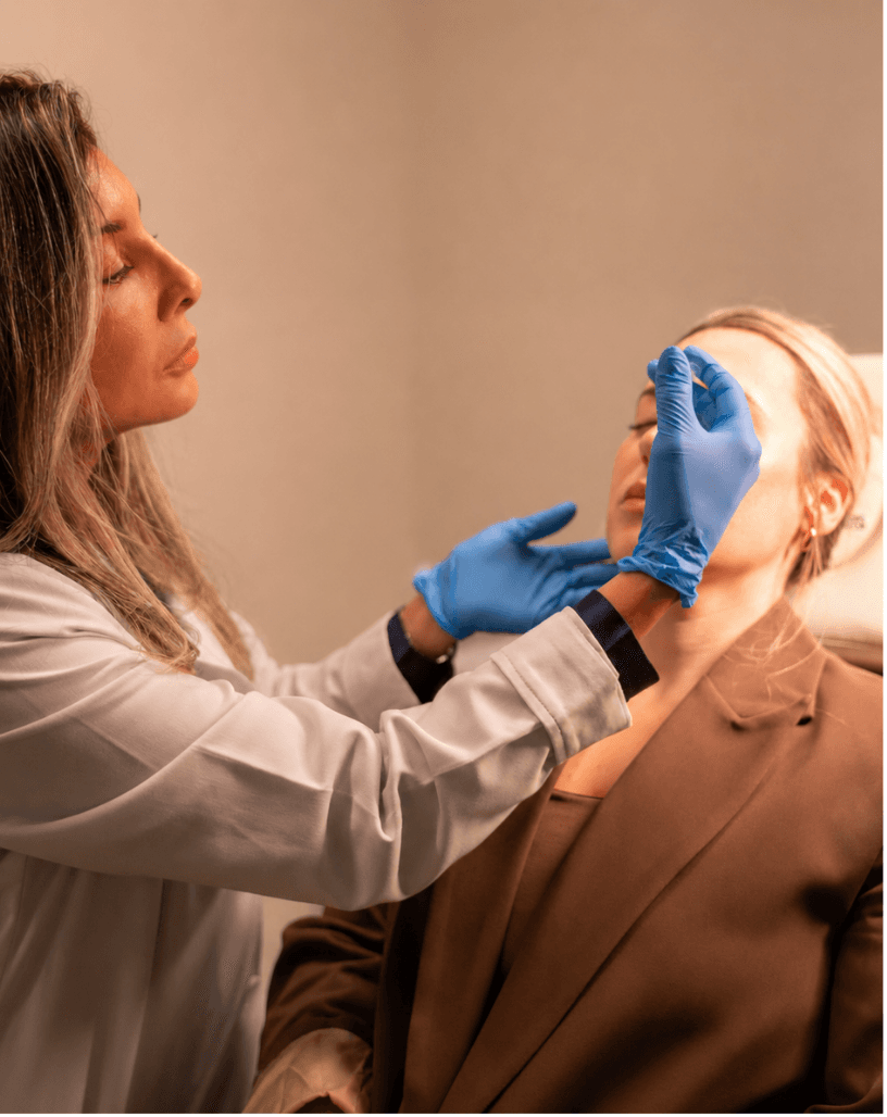 Specialist assessing a client's face before an aesthetic treatment